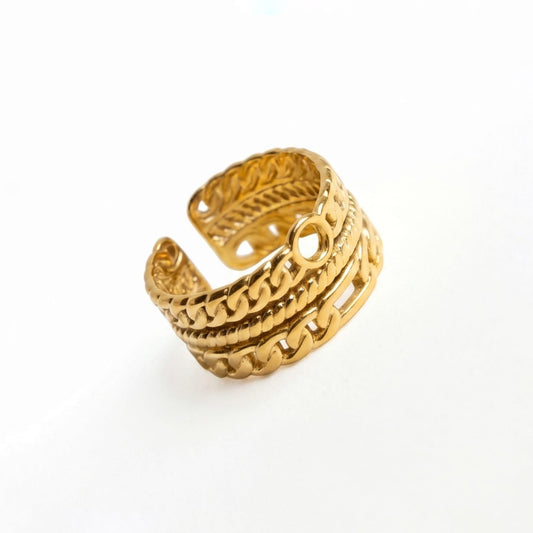 Gold ring with intricate design on a white background