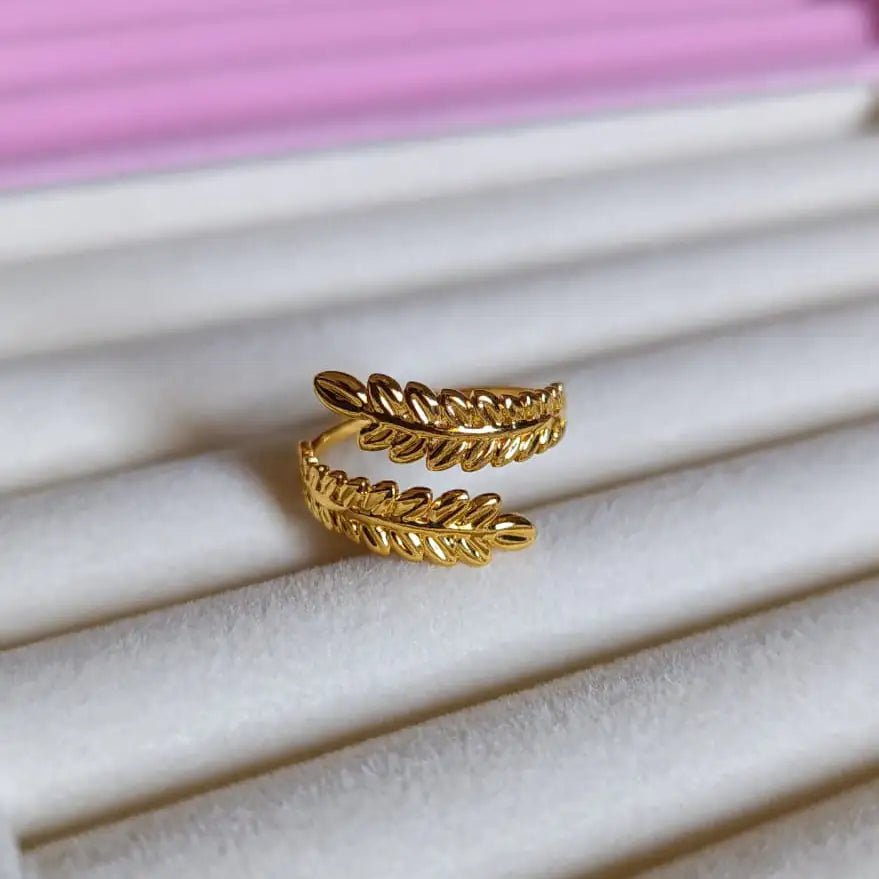 Gold leaf-shaped ring on a white and pink jewelry display - Botanica ring - Glitters For Her