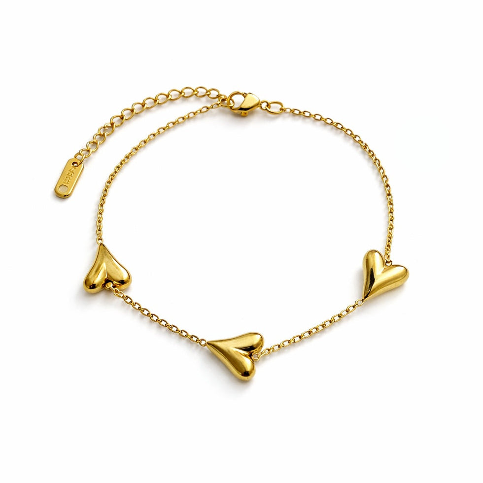 Gold bracelet with heart-shaped charms on a white background