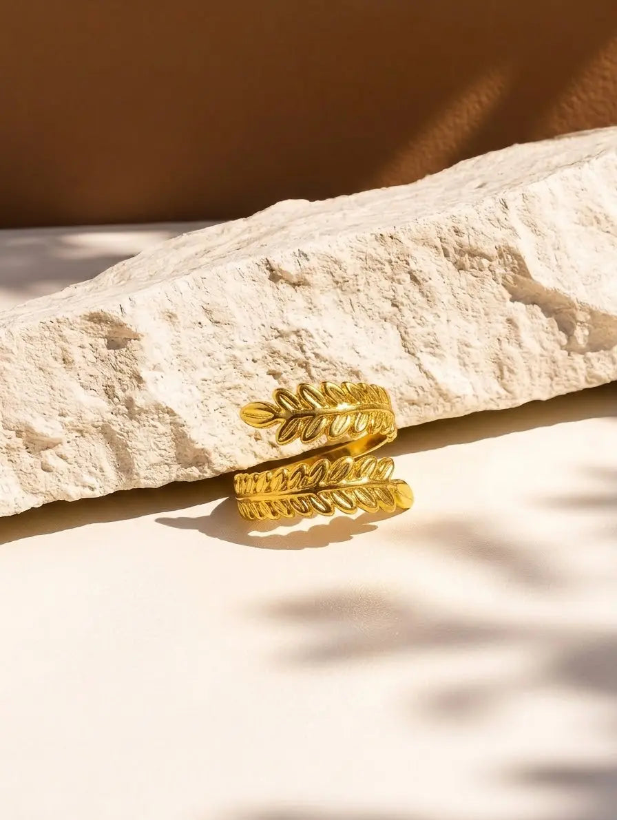 leaf design golden ring on a stone surface
