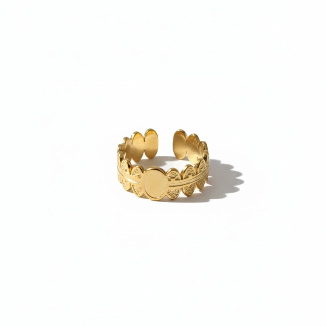 Gold ring with decorative design on a white background