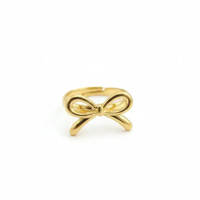 Gold bow-shaped ring on a white background