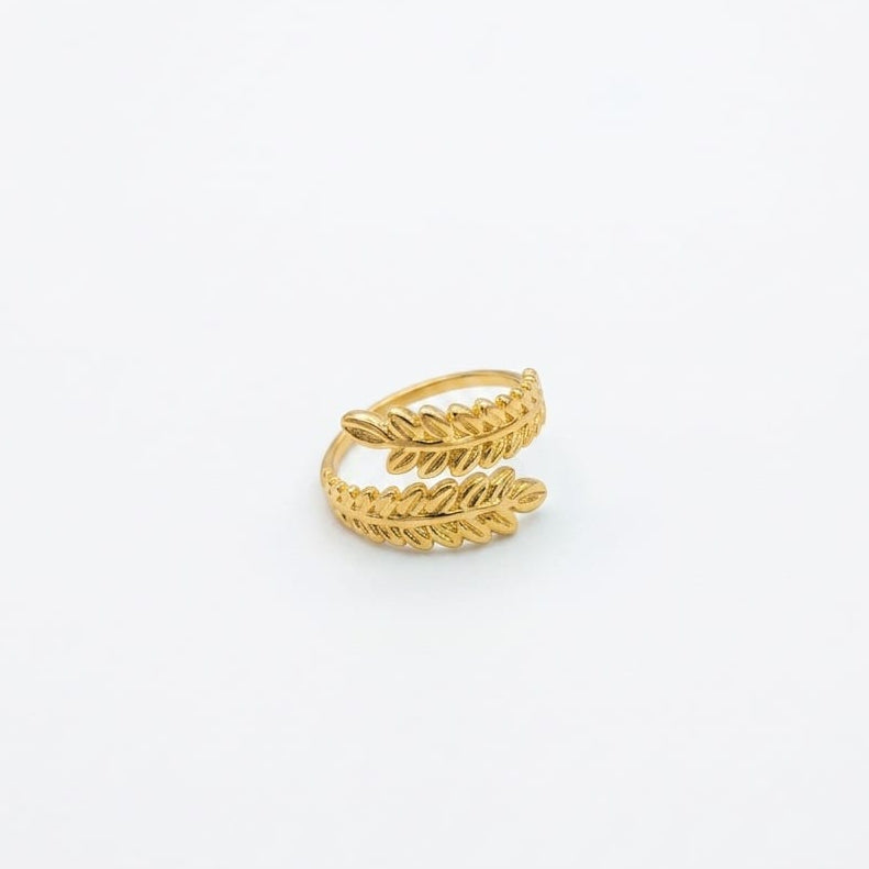 Gold leaf-shaped ring on a white background